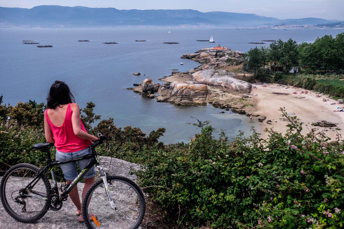 En cualquier alto del camino, las playas y el faro se perfilan sobre la ría repleta de bateas. En cualquier alto del camino, las playas y el faro se perfilan sobre la ría repleta de bateas.