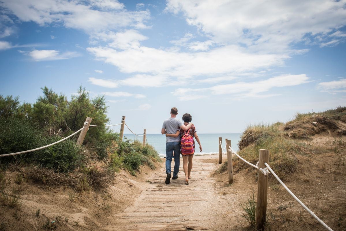 Un pareja pasea por la playa de Pinedo, en El Saler (Parque Natural de la Albufera, Valencia).