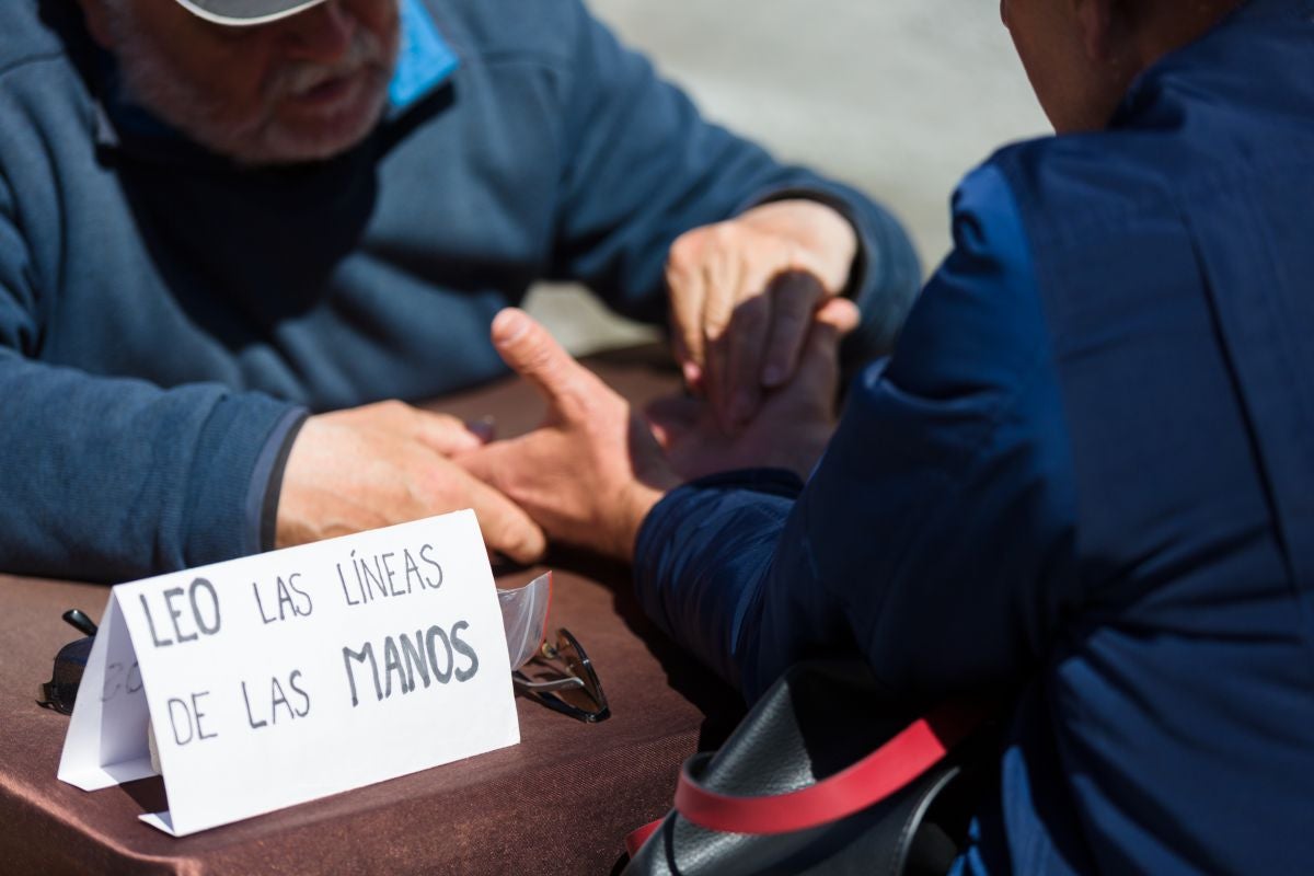 Un hombre lee las líneas de la mano en el mercadillo de Las Dalias, Ibiza. Un hombre lee las líneas de la mano en el mercadillo de Las Dalias, Ibiza.